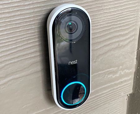Close up of smart doorbell against a home exteriors wall.